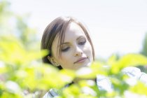 Mujer al aire libre rodeada de plantas verdes - foto de stock