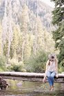 Donna seduta su un ponte di legno — Foto stock