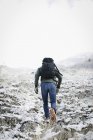 Homem caminhando pelas montanhas — Fotografia de Stock