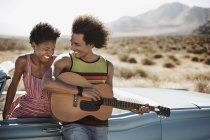 Couple standing by a pale blue convertible — Stock Photo