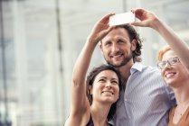 Homem e mulher em uma cidade, tomando uma selfie — Fotografia de Stock