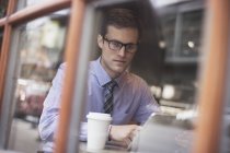 Бизнесмен, сидящий в кафе, используя ноутбук — стоковое фото