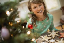 Girl with tray of baked Christmas cookies — Stock Photo