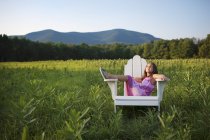Young girl sitting in chair — Stock Photo