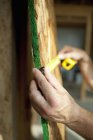 Людина вимірює дерев'яну дошку — стокове фото