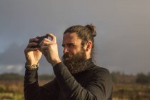 Чоловік стоїть за допомогою смартфона — стокове фото