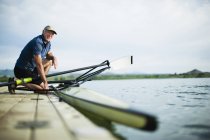 Man on jetty preparing a rowing boat — Stock Photo