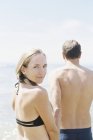 Casal em roupa de banho junto ao oceano — Fotografia de Stock
