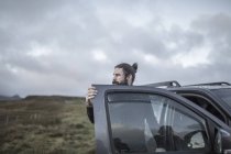 Mann steht vor offener Autotür — Stockfoto