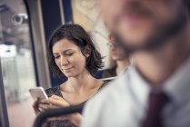 Femme dans un bus regardant le téléphone portable — Photo de stock