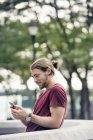 Людина в парку перевіряє свій мобільний телефон — стокове фото