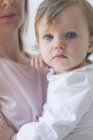 Young girl in her mother's arms. — Stock Photo