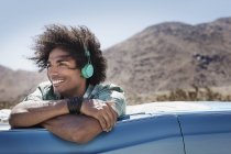 Hombre con auriculares de música en el coche - foto de stock