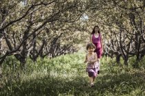 Children walking in a woodland tunnel — Stock Photo