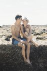 Couple assis sur la plage — Photo de stock