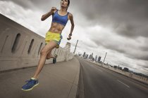 Жінка біжить міською дорогою — стокове фото
