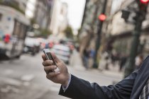 Бізнесмен перевіряє телефон на вулиці — стокове фото