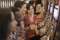 Personas jugando las máquinas tragamonedas en un casino . - foto de stock