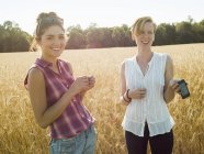 Молодые женщины, стоящие на пшеничном поле — стоковое фото