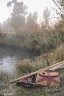 Creel de pesca e cobertor na margem do rio — Fotografia de Stock