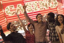 Pessoas sob um sinal brilhante do casino do neon . — Fotografia de Stock