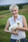 Teenager hält ein Huhn in der Hand — Stockfoto