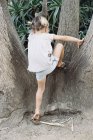 Loira cabelos menina escalando uma árvore — Fotografia de Stock