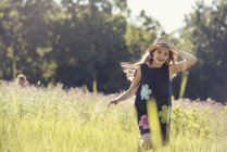 Menina em chapéu de palha em um prado — Fotografia de Stock