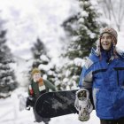 Giovane ragazzo che trasporta uno snowboard — Foto stock