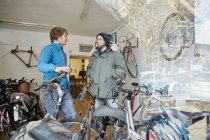 Young men in a cycle shop — Stock Photo