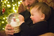 Father and baby looking at snow globe — Stock Photo