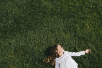 Nine year old girl on green grass — Stock Photo