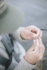 Tying a fishing fly onto a hook. — Stock Photo