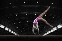 Mujer gimnasta realizar en la viga - foto de stock