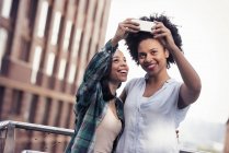Deux femmes prenant un selfie dans la ville — Photo de stock