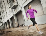 Frau läuft auf einer Stadtstraße — Stockfoto