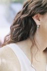 Frau trägt silbernen und türkisfarbenen Ohrring. — Stockfoto