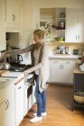 Mulher de pé em uma cozinha — Fotografia de Stock