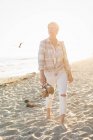 Женщина, идущая вдоль пляжа — стоковое фото