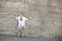 Жінка спирається на скелю — стокове фото