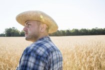 Agriculteur debout dans un champ de blé — Photo de stock