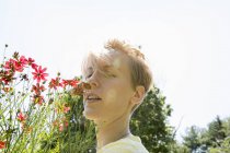 Mulher de pé cara a cara com flores gama rudbeckia — Fotografia de Stock