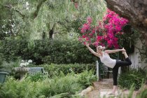 Mujer haciendo yoga en un jardín . - foto de stock