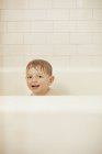 Jeune garçon assis dans une baignoire — Photo de stock