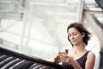 Mujer revisando su teléfono celular - foto de stock