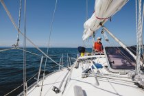 Middle aged man steering sailboat — Stock Photo