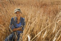 Donna seduta sorridente in un campo — Foto stock