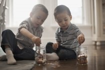 Двоє дітей грають з монетами — стокове фото