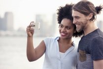 Homem e mulher tomando uma selfie em uma cidade — Fotografia de Stock