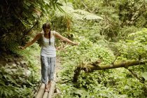 Жінка йде бамбуковим мостом — стокове фото